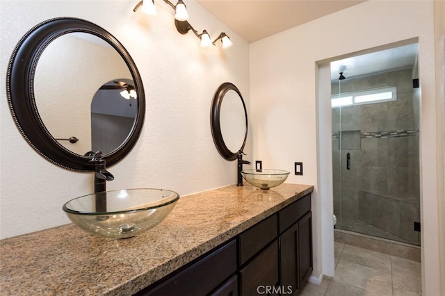 bathroom featuring walk in shower, tile patterned floors, and vanity