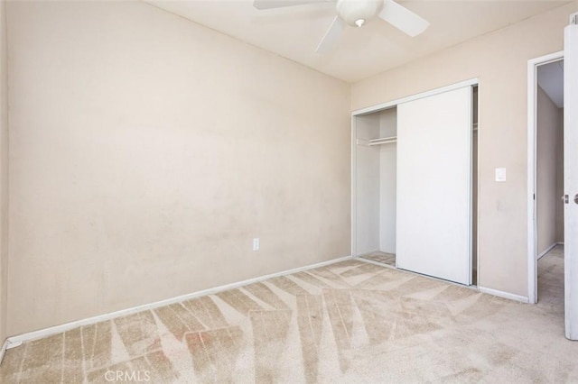 unfurnished bedroom featuring light carpet, ceiling fan, and a closet