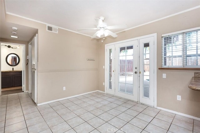 doorway with crown molding, plenty of natural light, light tile patterned floors, and ceiling fan