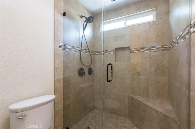 bathroom featuring an enclosed shower and toilet