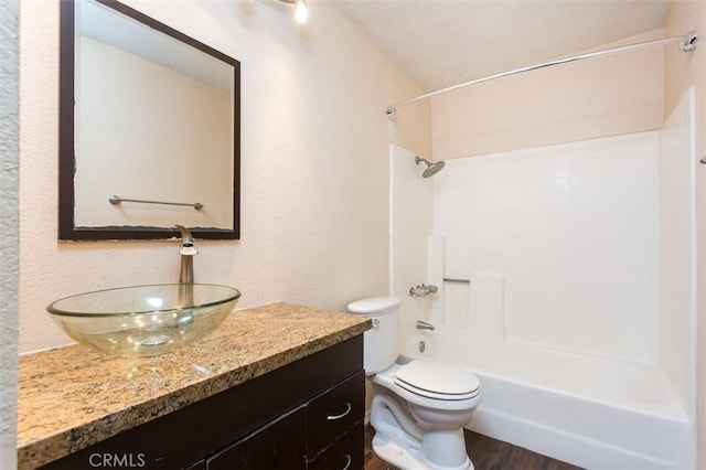 full bathroom featuring shower / washtub combination, toilet, hardwood / wood-style floors, and vanity