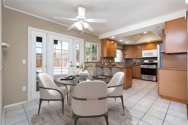 dining area with sink, crown molding, ceiling fan, and light tile patterned flooring