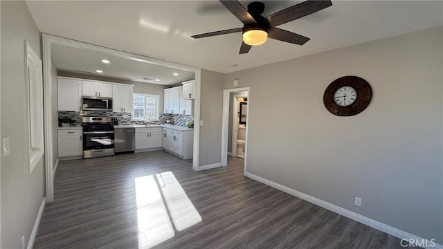 kitchen featuring dark hardwood / wood-style floors, ceiling fan, appliances with stainless steel finishes, and white cabinetry