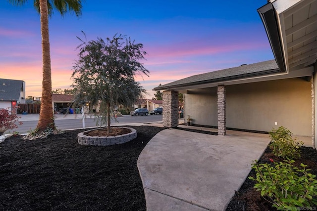 yard at dusk featuring a patio area