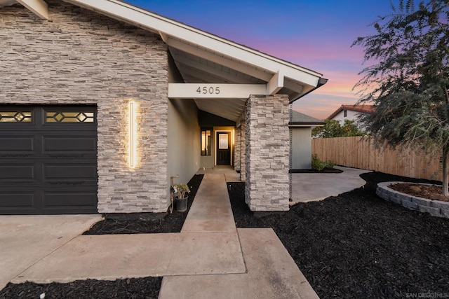 exterior entry at dusk with a garage