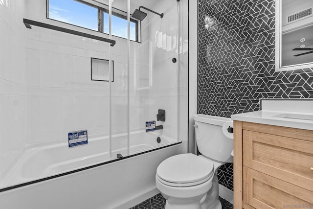 full bathroom featuring toilet, enclosed tub / shower combo, ceiling fan, tile walls, and vanity