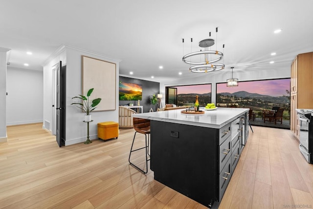 kitchen featuring light hardwood / wood-style floors, a chandelier, pendant lighting, a breakfast bar, and a center island