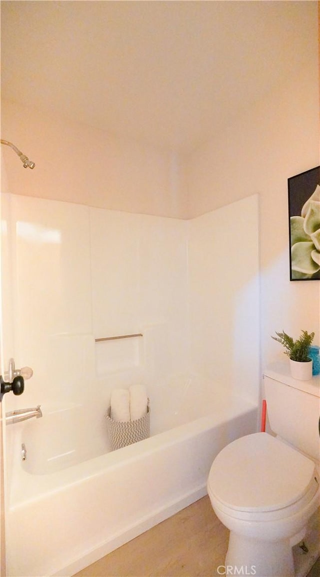 bathroom featuring toilet, shower / bathtub combination, and hardwood / wood-style flooring