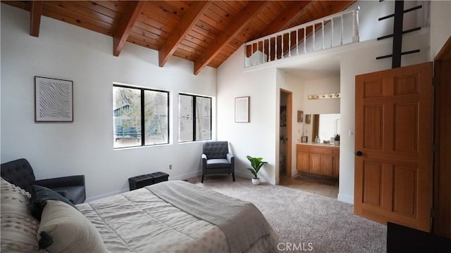 carpeted bedroom featuring wooden ceiling, beam ceiling, high vaulted ceiling, and ensuite bathroom