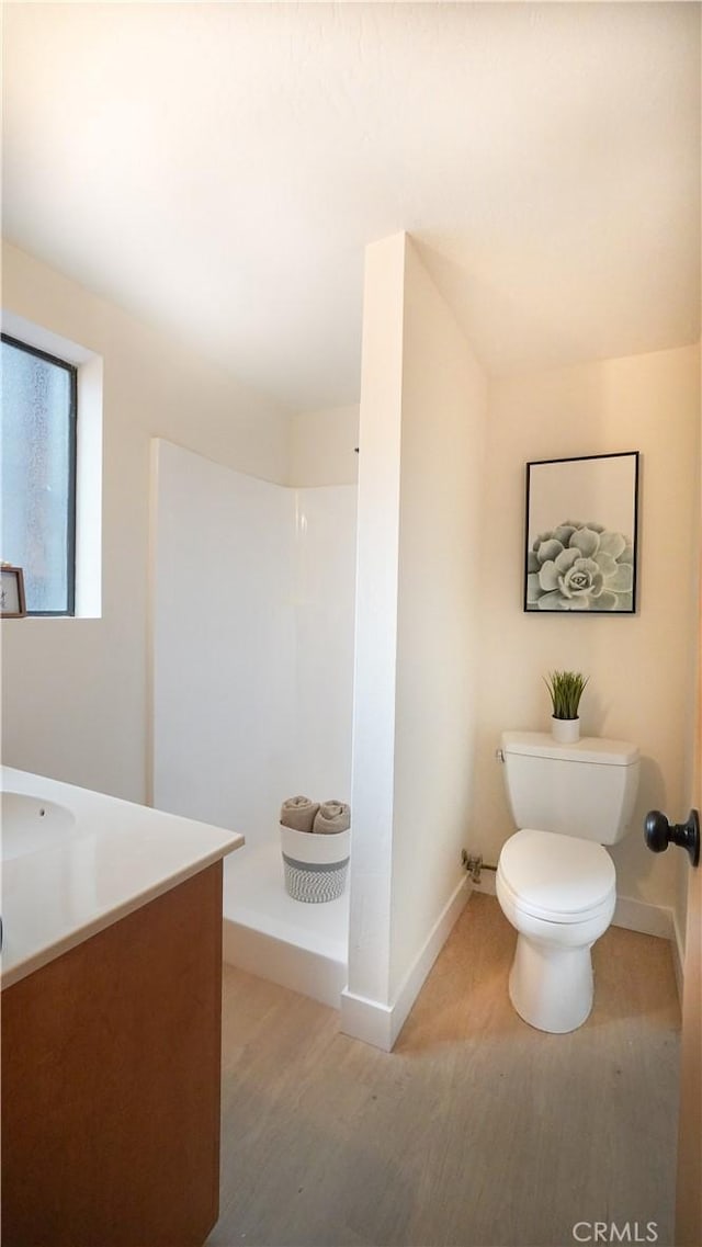 bathroom with a shower, wood-type flooring, toilet, and vanity