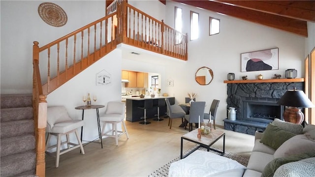 living room featuring high vaulted ceiling, beamed ceiling, and a fireplace