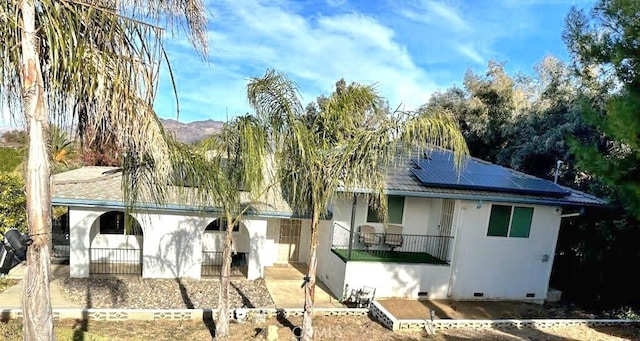 view of front facade with a mountain view and solar panels