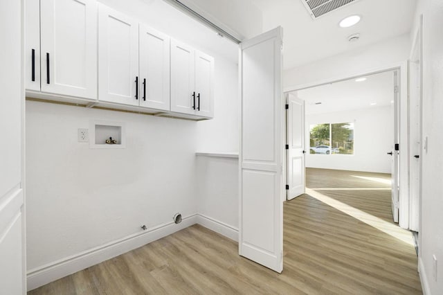 clothes washing area featuring hookup for a gas dryer, light hardwood / wood-style flooring, hookup for a washing machine, and cabinets