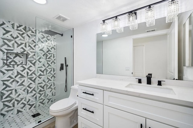 bathroom featuring toilet, vanity, and a shower