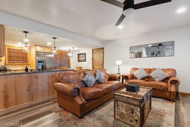 living room with ceiling fan and dark hardwood / wood-style flooring