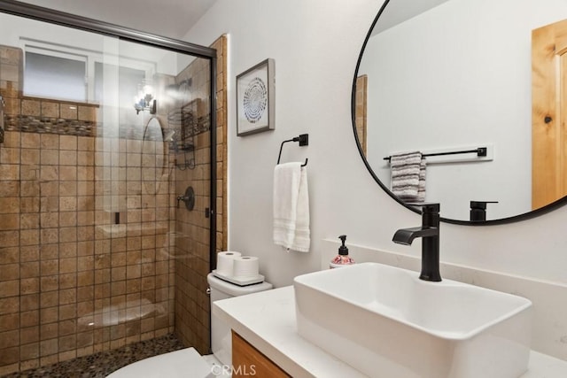 bathroom with toilet, vanity, and a shower with door