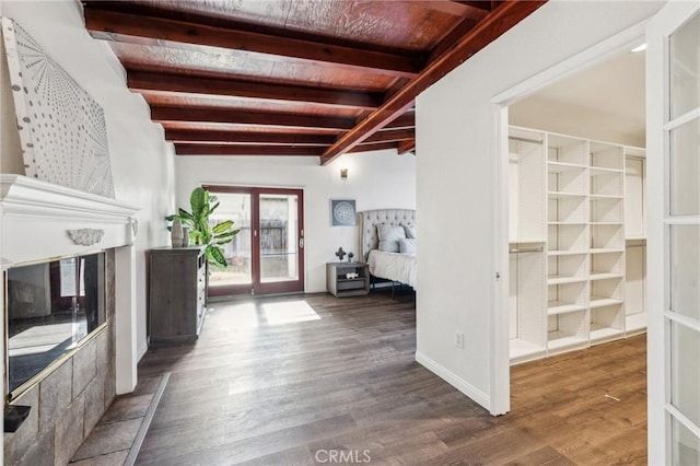 foyer entrance featuring a large fireplace, wood ceiling, beam ceiling, and dark wood-type flooring