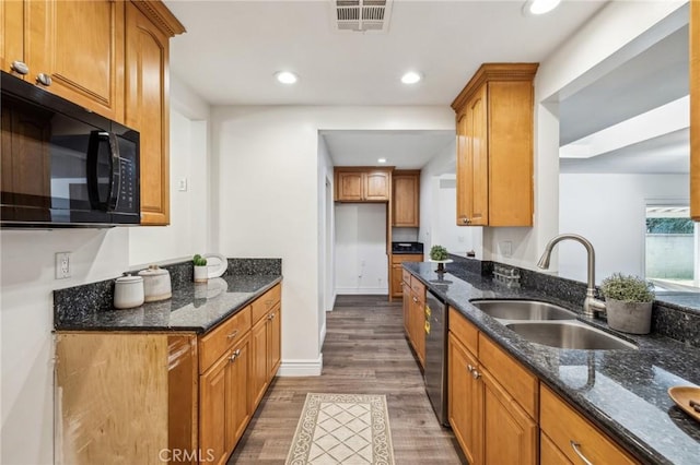 kitchen with visible vents, stainless steel dishwasher, a sink, dark stone counters, and black microwave