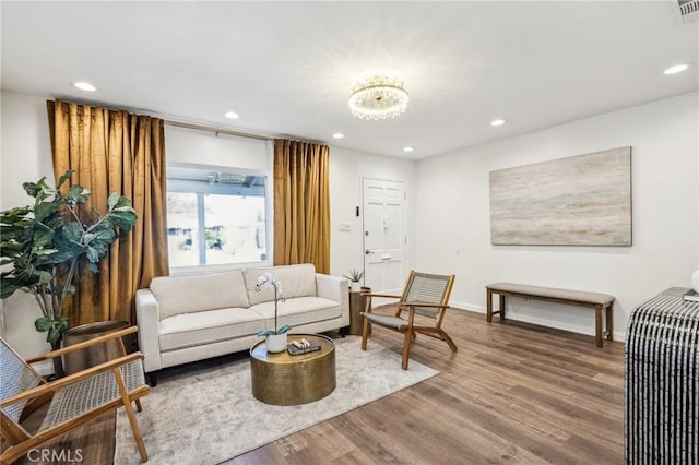 living room with baseboards, a notable chandelier, wood finished floors, and recessed lighting