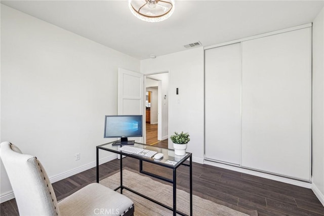 office area featuring visible vents, dark wood finished floors, and baseboards