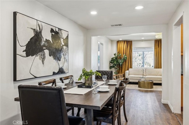 dining space featuring baseboards, visible vents, wood finished floors, and recessed lighting