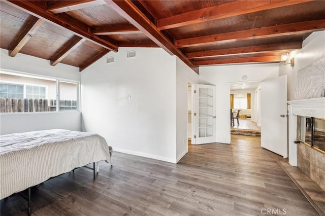 bedroom with a fireplace with flush hearth, wood ceiling, visible vents, and wood finished floors