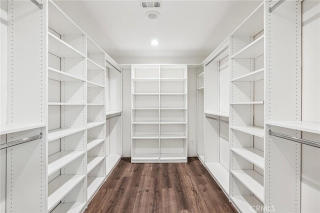 spacious closet featuring dark wood-style flooring and visible vents