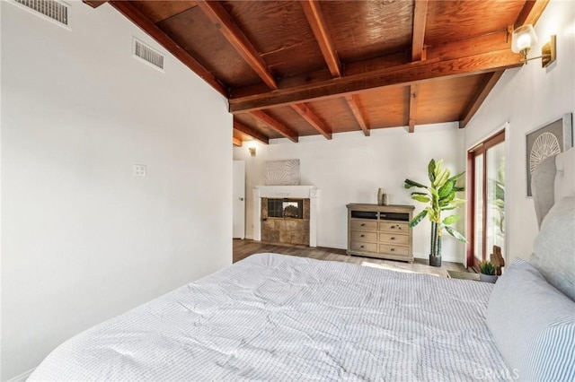 bedroom with a glass covered fireplace, wood ceiling, visible vents, and wood finished floors