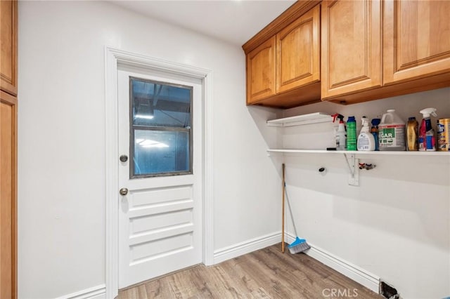 laundry room featuring light wood finished floors and baseboards