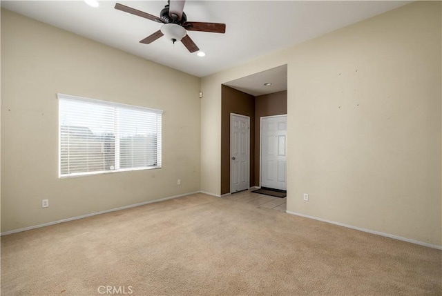 carpeted spare room featuring ceiling fan