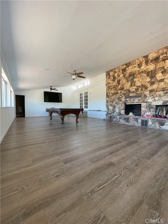 game room with ceiling fan, hardwood / wood-style floors, billiards, and a stone fireplace