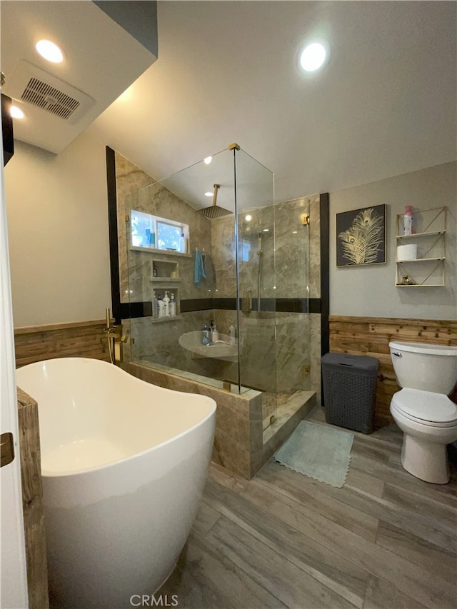 full bathroom featuring vaulted ceiling, independent shower and bath, toilet, and sink