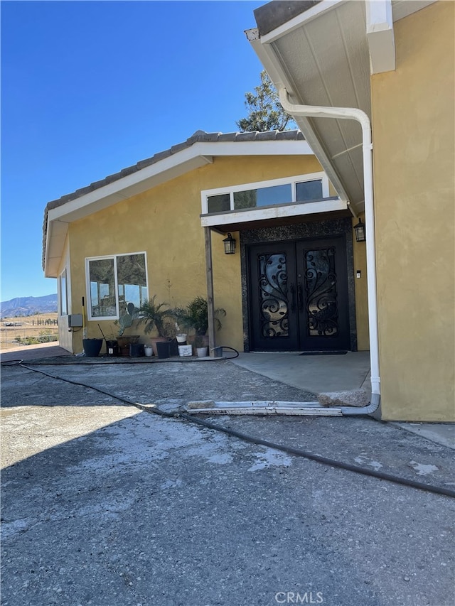 view of exterior entry featuring french doors and a mountain view