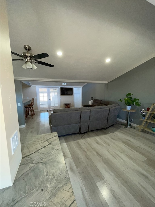 unfurnished living room featuring ceiling fan, french doors, ornamental molding, and light hardwood / wood-style floors