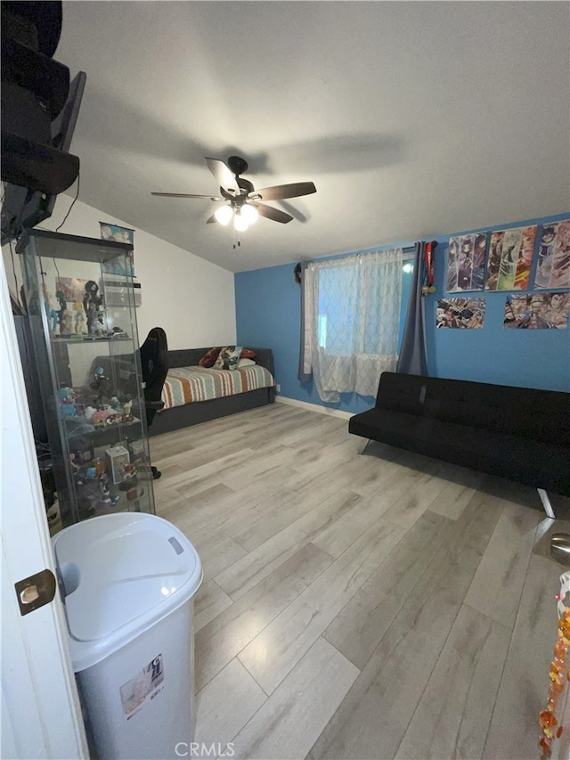 bedroom with ceiling fan, light wood-type flooring, and lofted ceiling