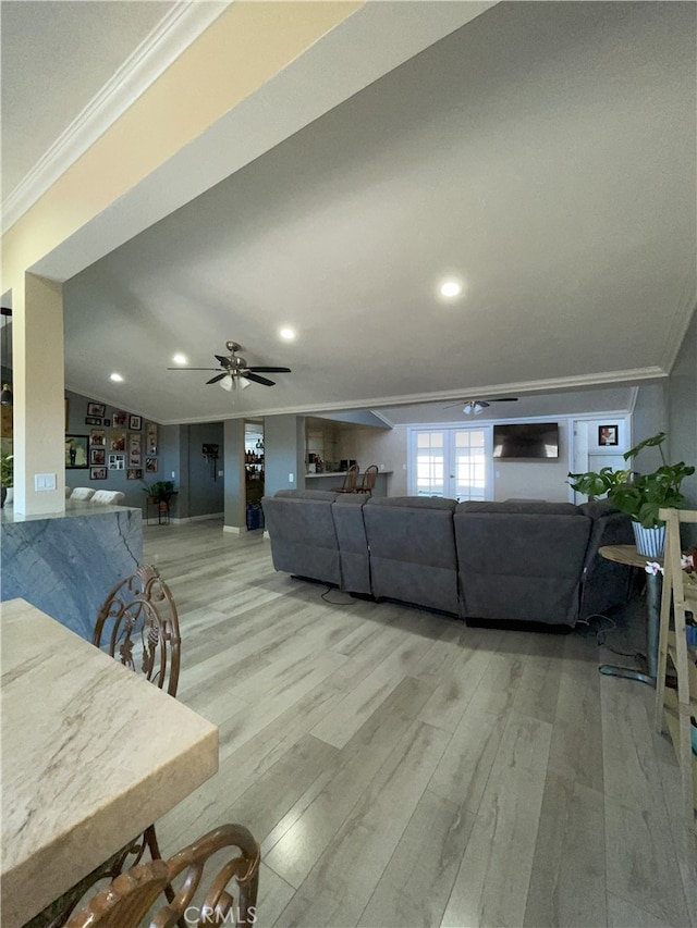 living room featuring ceiling fan, light hardwood / wood-style floors, and crown molding