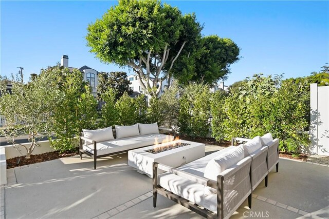 view of patio with an outdoor living space with a fire pit