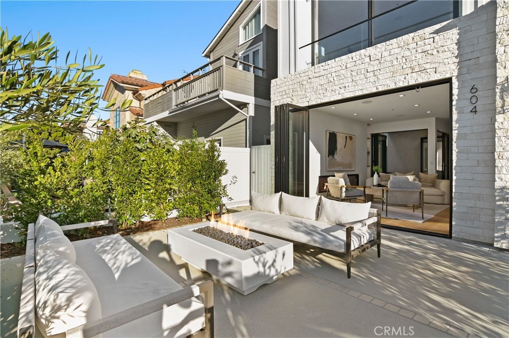 view of patio with an outdoor living space with a fire pit