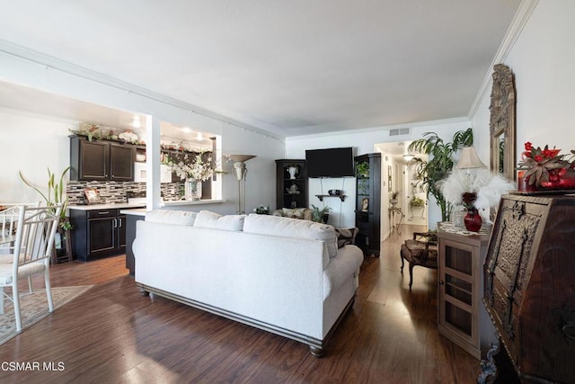 living room featuring dark wood-type flooring and crown molding