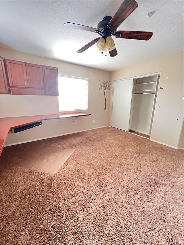 unfurnished bedroom with a textured ceiling, ceiling fan, and a closet