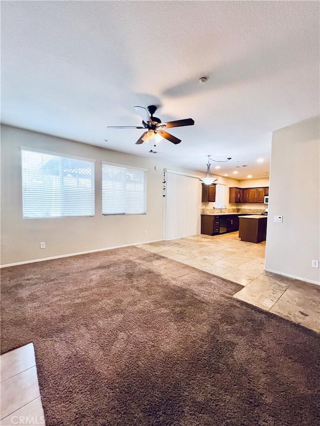 unfurnished living room featuring ceiling fan and light carpet