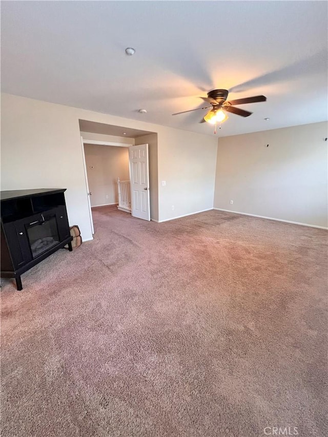 unfurnished living room featuring ceiling fan and carpet floors