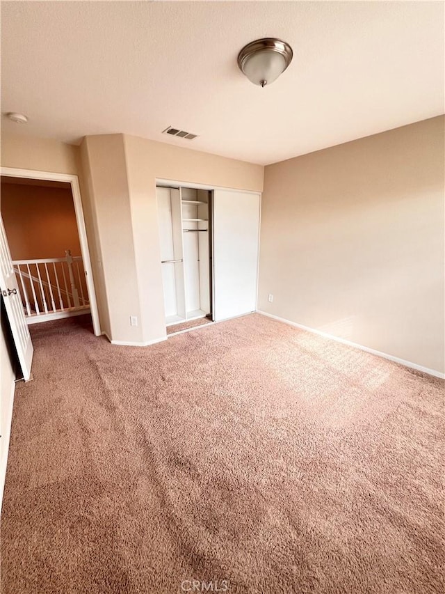 unfurnished bedroom with a closet and carpet flooring