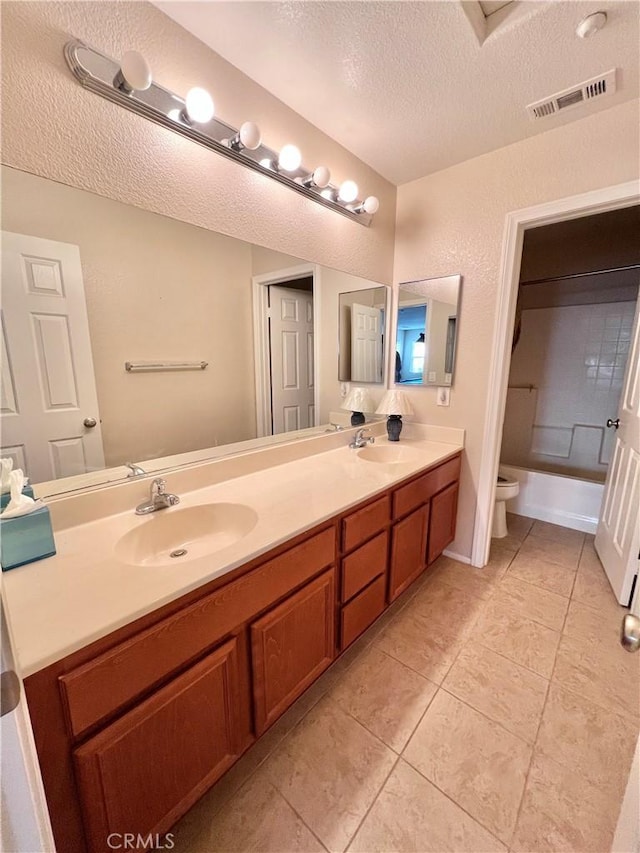 bathroom featuring a textured ceiling, toilet, and vanity