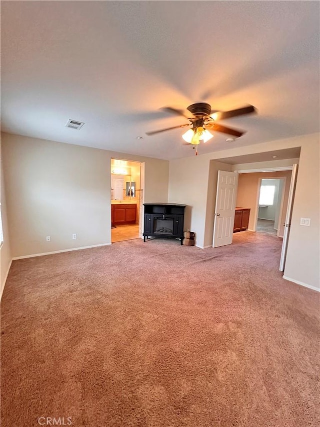 unfurnished living room featuring ceiling fan and carpet