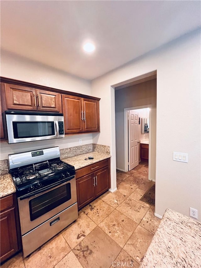 kitchen with light stone countertops and stainless steel appliances