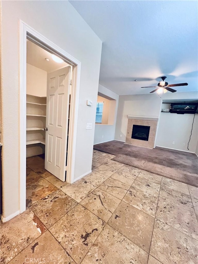 unfurnished living room with ceiling fan