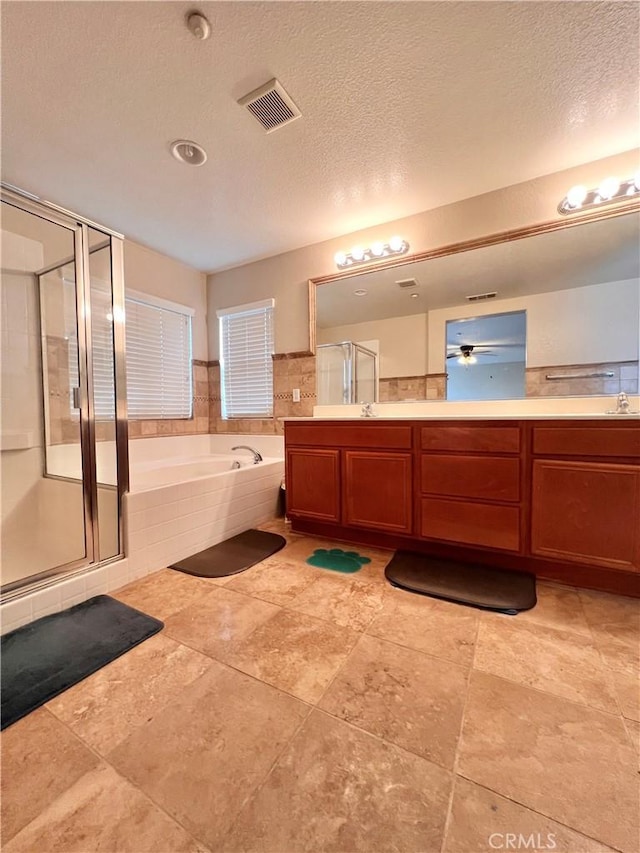 bathroom featuring a textured ceiling, independent shower and bath, and vanity