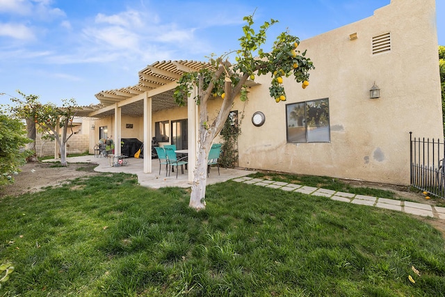 rear view of property with a pergola, a patio area, and a lawn