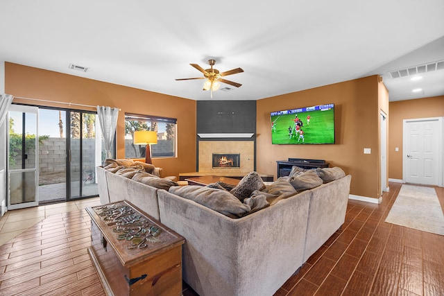 living room featuring ceiling fan and a fireplace